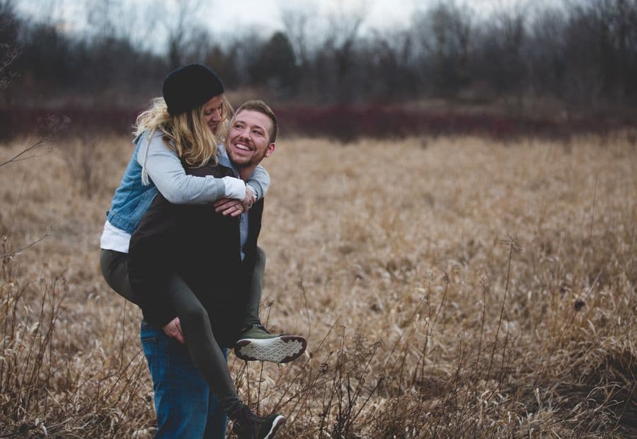 A couple laughing together in an open prairie field