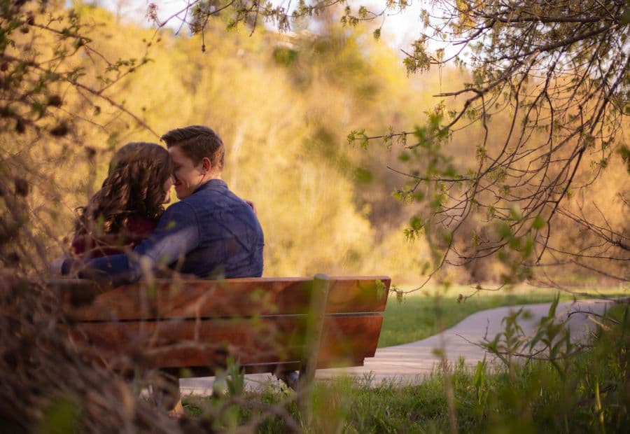 A couple sharing a quiet, private moment on a park bench