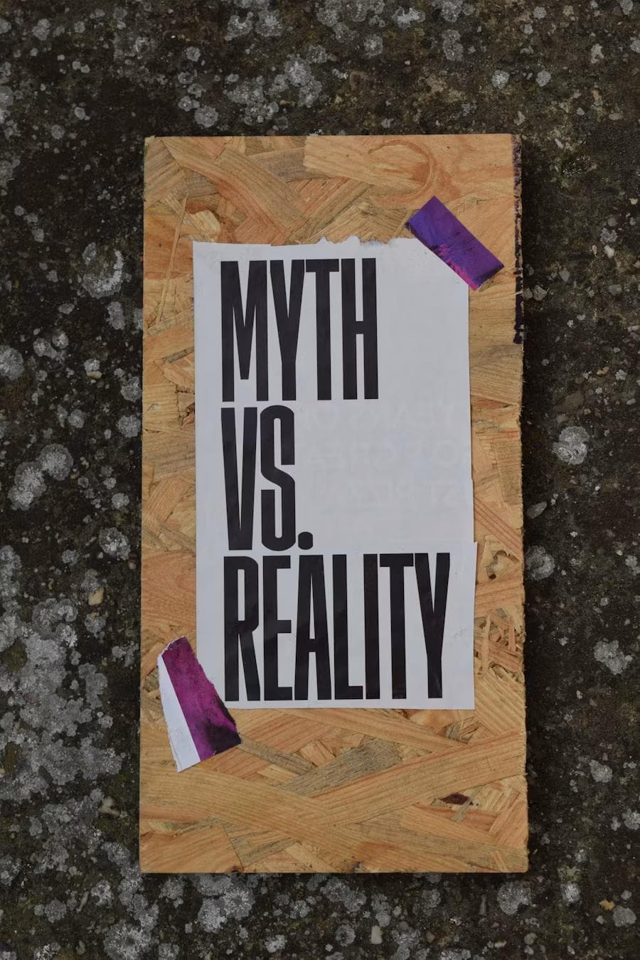 A paper sign reading MYTH VS. REALITY taped to a wooden board, illustrating the misconception that there are no good matches left when dating apps actually just reduce visibility for users over 30