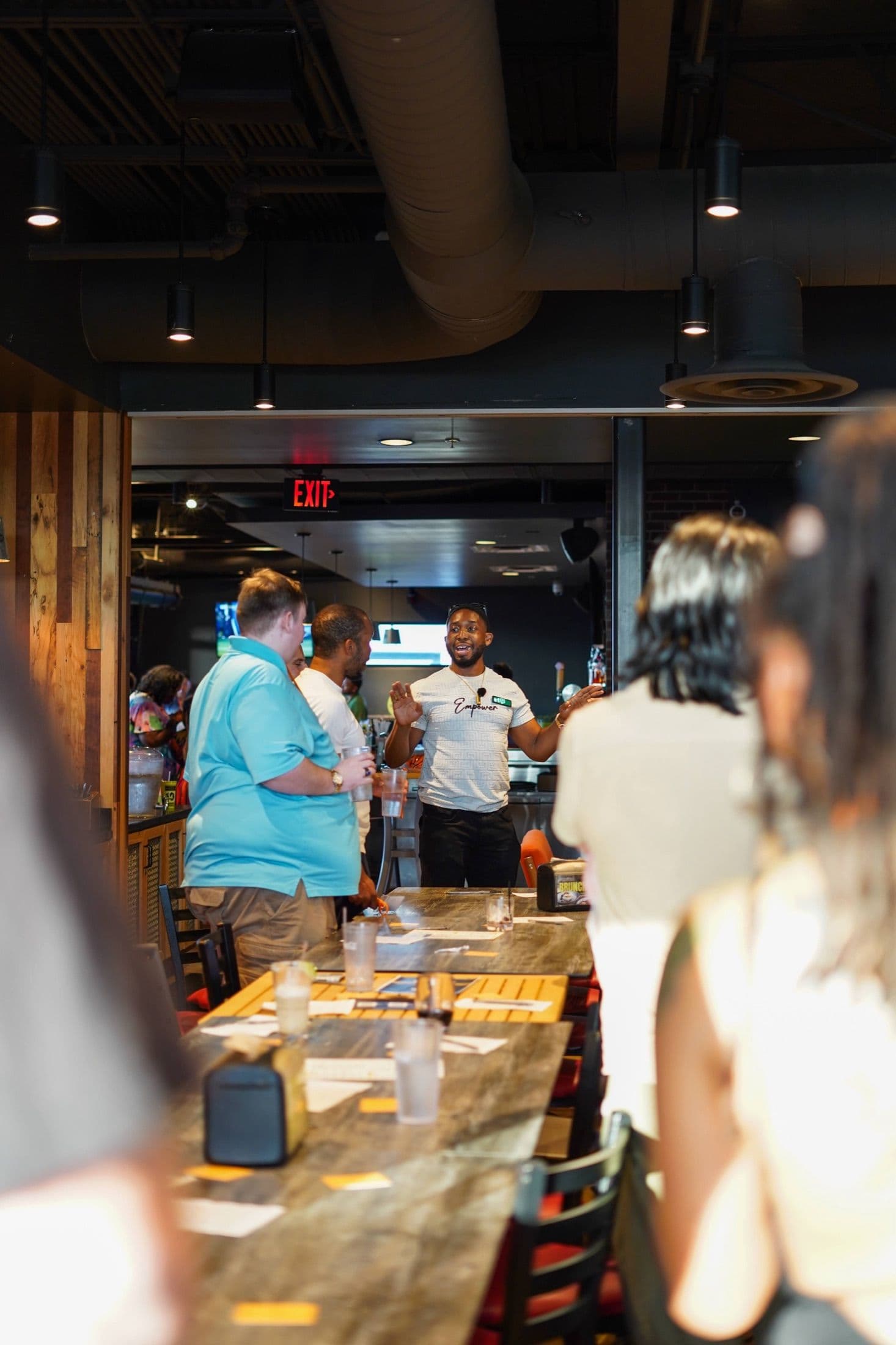 A host welcoming guests across the room at a Beyond The Sparks compatibility dating event.