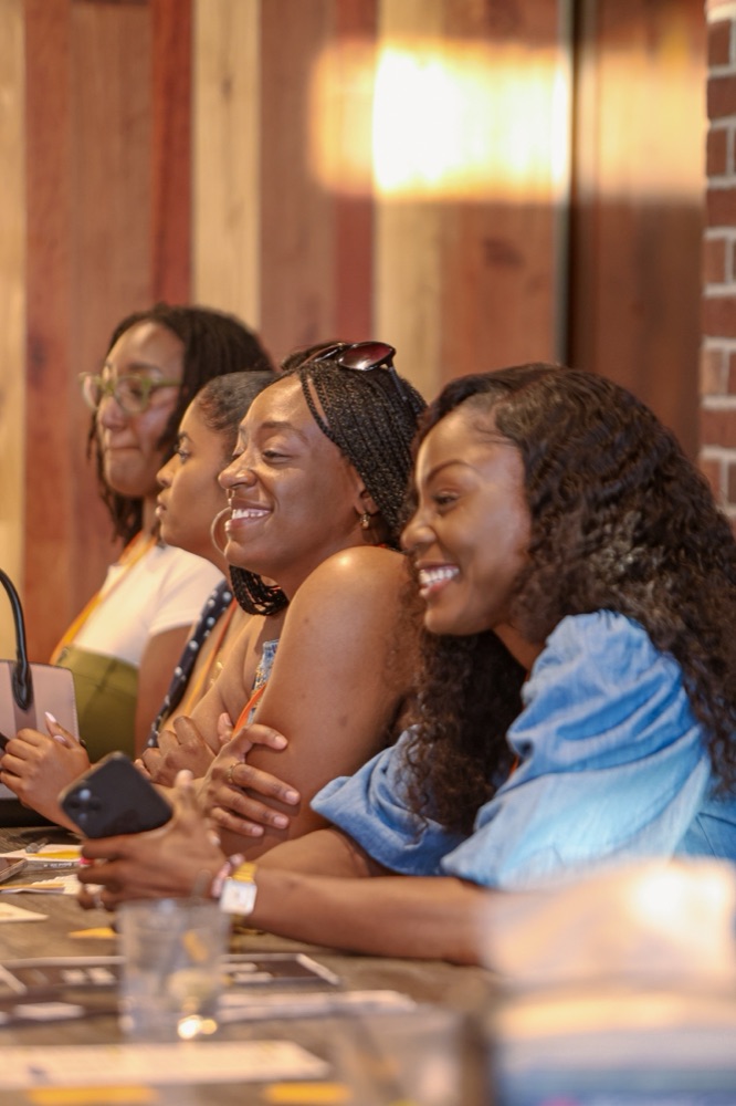 A row of women guests laughing together at a Beyond The Sparks singles event.