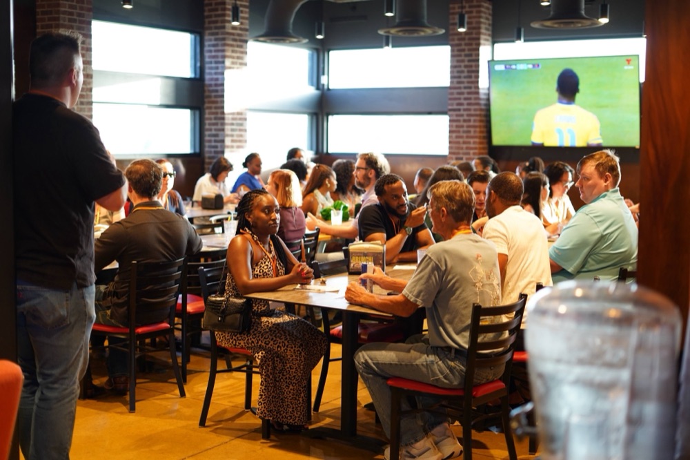 A full room of guests seated at tables in conversation during a Beyond The Sparks dating event.
